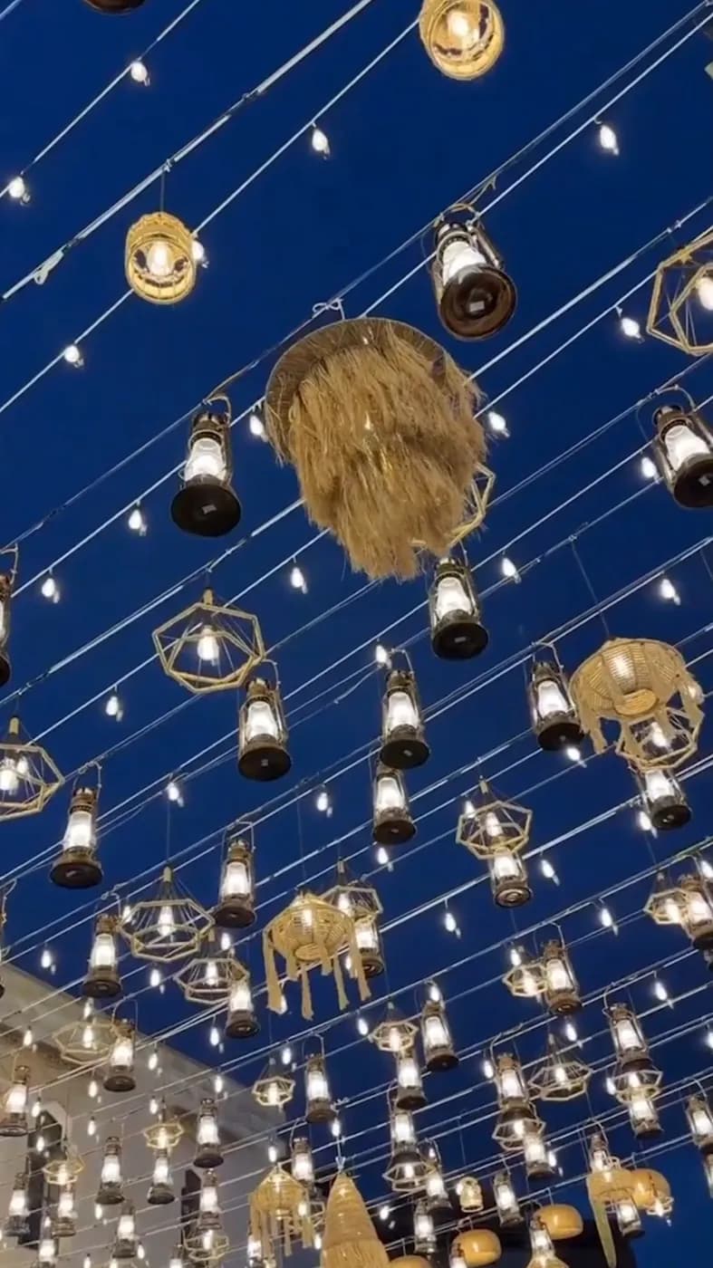 Hanging lanterns and festoon lights over an evening celebration